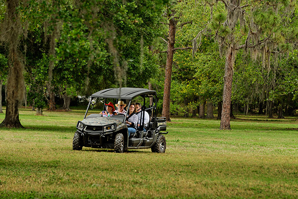 Four participants take a spin around the reserve portion of Calvary Catholic Cemetery in John Deere's XVU-550 all-terrain vehicle.