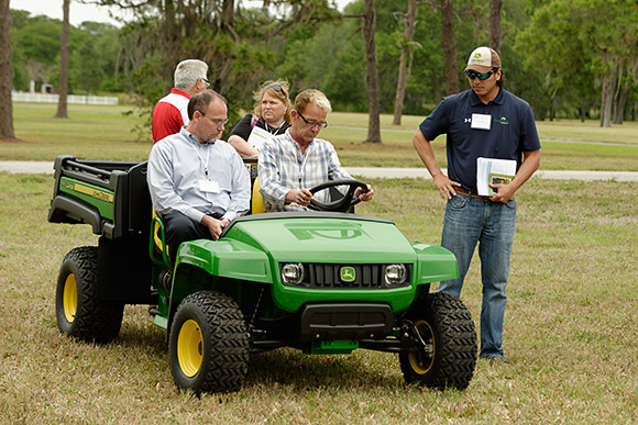 Andy Goya, at right, shows some of the participants one of John Deere's small utility vehicles.