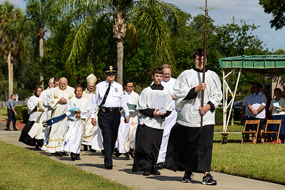 Altar servers from the Cathedral of St. Jude the Apostle lead the procession of priests and deacons to the out-of-door altar to begin the Annual Memorial Day Mass.