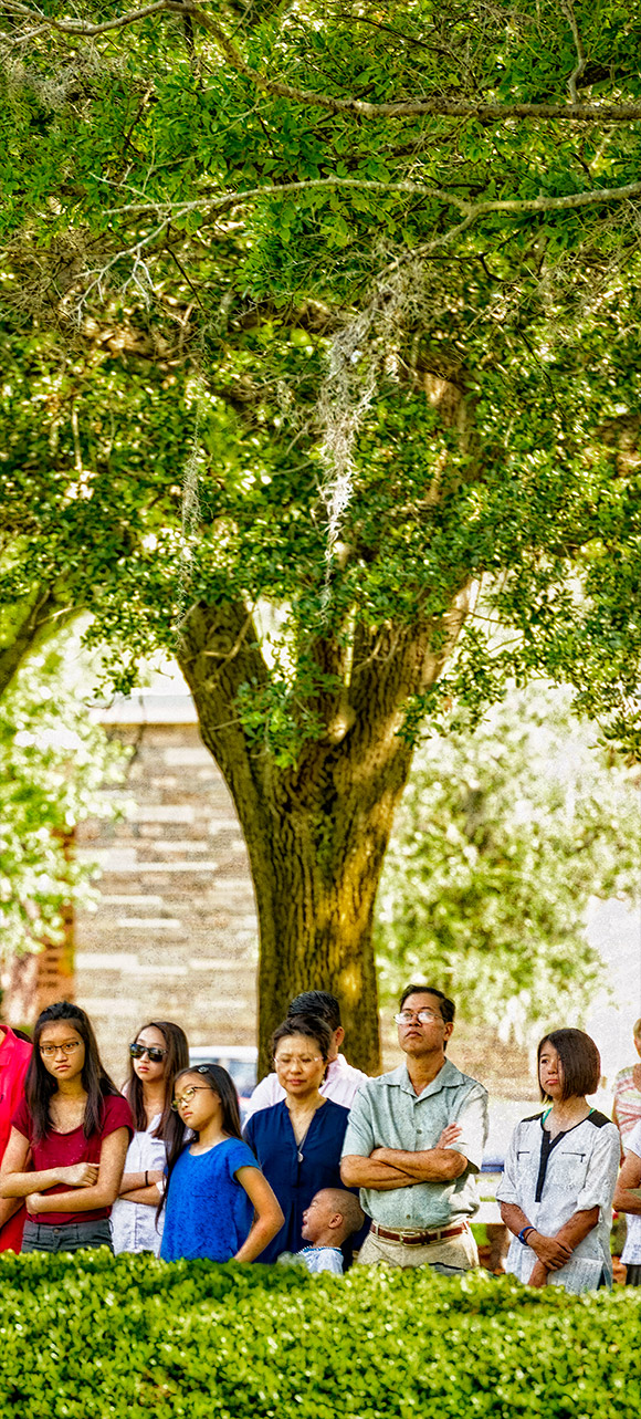 This family found shade beneath the canopy of one of the huge oak trees near the outdoor altar. | Photo: © 2016 Ed Foster Jr.