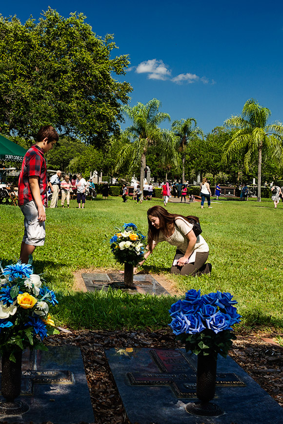 Betsy Marrero kneels at the grave of Father Tom Tobin as her 11-year-old son, Ian, looks on. She knew Father Tobin from the time that he served at Sacred Heart Parish in Pinellas Park. "I loved his enthusiasm. He was always happy and he had a beautiful heart and soul." | Photo: © 2016 Ed Foster Jr.