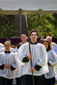 Cross Bearer, Noah Saliado, leads the recessional at the conclusion of Mass on Memorial Day.