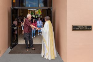 Calvary Catholic Cemetery Chaplain, Father Hugh Chikawe, greets Herman Wells after the Month's Mind Mass on July 27, 2019.
