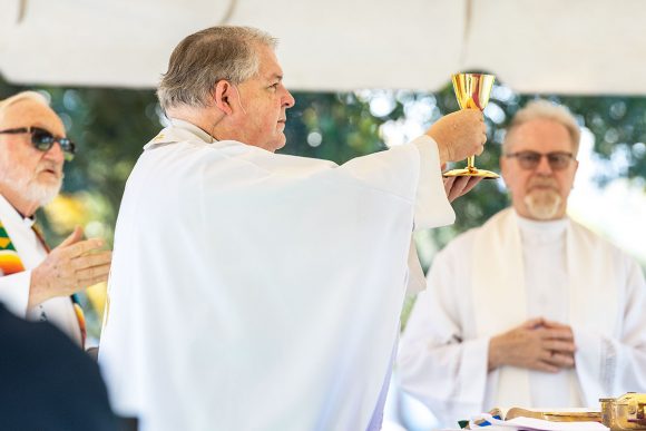 Msgr. Michael Muhr raises the chalice of Precious Blood at the Consecration of the Mass.