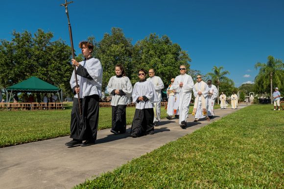 As Mass begins on Memorial Day, altar servers from the Cathedral Parish of St. Jude the Apostle lead the procession to the altar followed by Msgr. Robert Morris, and Fathers Jean Robitaille, Joel Kovanis, Thomas Anastasia, Deacon Eusebio "Papo" Torres and Father Hugh Chikawe, Chaplain of Calvary Catholic Cemetery.