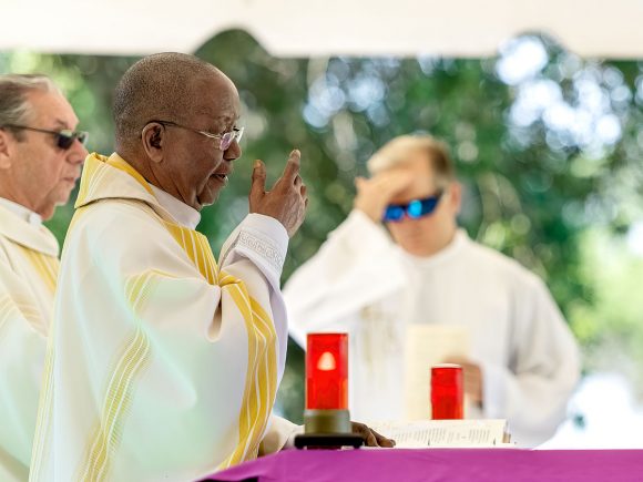 "In the name of the Father, the Son and the Holy Spirit," Father Hugh Chikawe says as he makes the Sign of the Cross to begin Mass on Memorial Day.