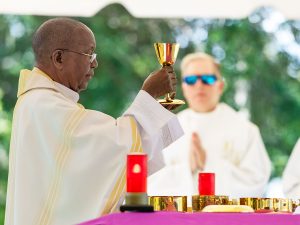 Father Hugh Chikawe raises the chalice with the Blood of Christ as he celebrates Mass on this Memorial Day.