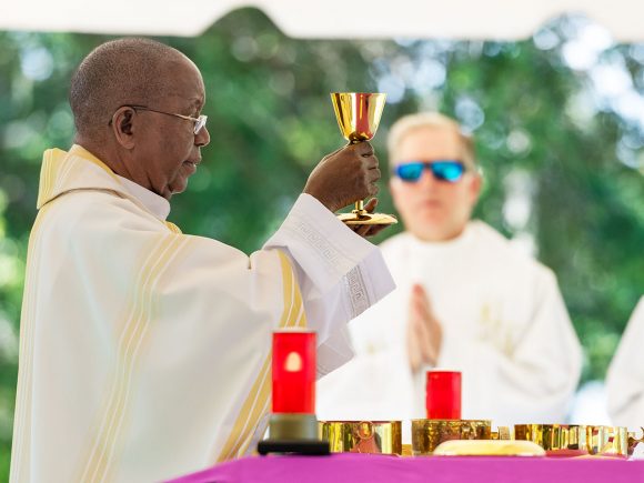 Father Hugh Chikawe raises the chalice with the Blood of Christ as he celebrates Mass on this Memorial Day.