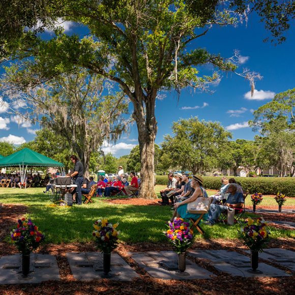 Some of the faithful take advantage of shade beneath the majestic oaks that flank the graves of departed bishops and priests who have served the Diocese of St. Petersburg.
