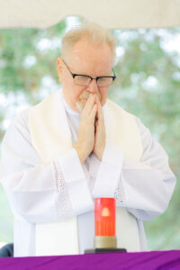 Marians of the Immaculate Conception Father Andrzej Gorczyca is reflected in prayer during Mass on All Soul's Day at Calvary Catholic Cemetery.