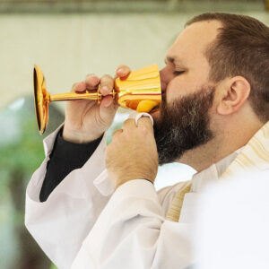 Father Joshua Bertrand consumes the Precious Blood during Communion.