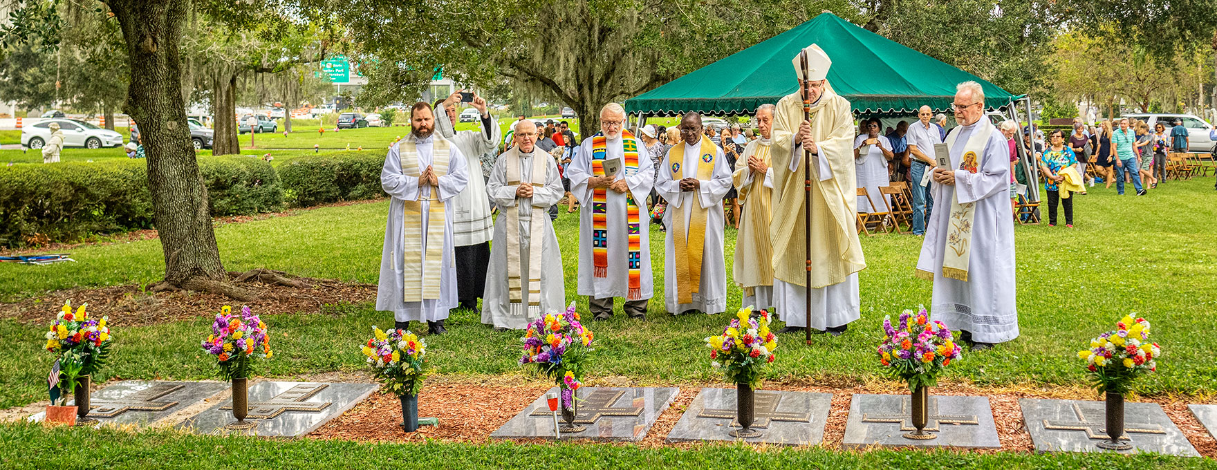 Most Reverend Gregory L. Parkes and priests and deacon of the Diocese of St. Petersburg pray at the graves of departed fellow priests on All Souls' Day at Calvary Catholic Cemetery in Clearwater, Fla.
