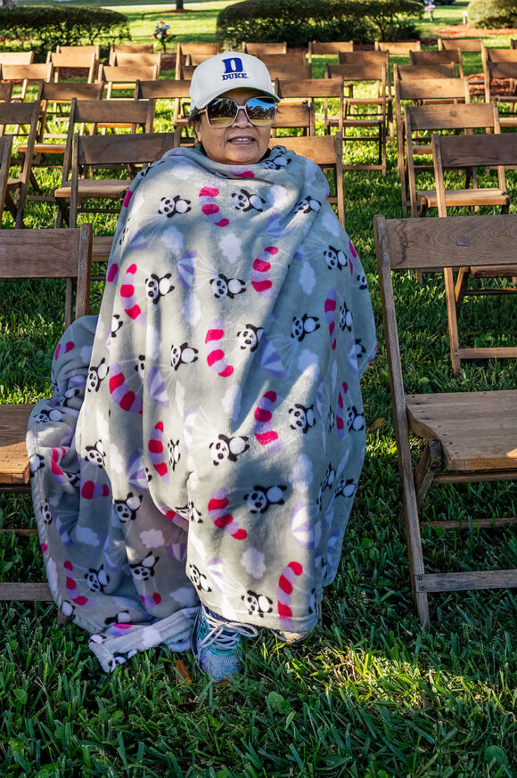 Prior to Mass on All Souls' Day at Calvary Catholic Cemetery, Edna Beckmann wards off the morning chill wrapped in her teddy bear blanket.