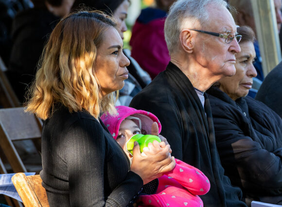 Five-year-old Amelie Dumaine rests on the lap of her mother, Ana, during Bishop Parke's homily. Ana attended the Mass on All Souls' Day with her friend, Missionaries of Africa Father Bill Curran.