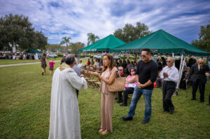 Fr. Francis X. Buu distributes the Body of Christ during Mass on All Souls’ Day at Calvary Catholic Cemetery.